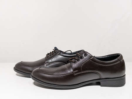 A pair of formal black shoes with laces displayed with white backgroundの写真素材