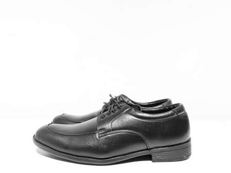 A pair of formal black shoes with laces displayed with white backgroundの写真素材