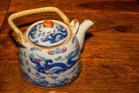 A tea pot with handle and traditional Chinese dragons made on it as designの写真素材