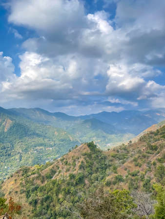 A mountain valley with green vegetation on it and hills all around itの写真素材