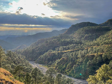 A landscape vista with mountains, river and beautiful cloud formation.の写真素材