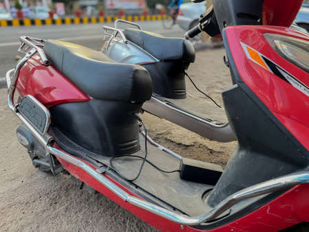 Two electric scooter charging with cable plugged in to itの写真素材