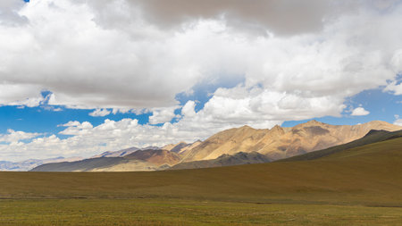 Grassland with mountain and clouds in the backgroundの写真素材