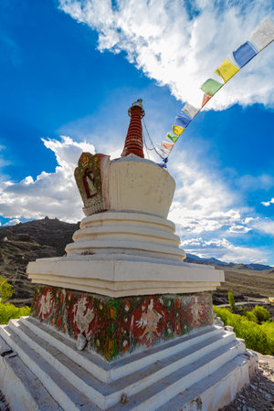 A white Stupa with colorful prayer flags tied on it at Leh, Ladakh India.の写真素材