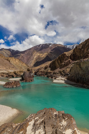 Landscape of sandy beaches amidst Jagged Mountain rocks and clear green water.の写真素材