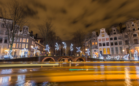 Tour boats decorate the canals with light trails as they are cruising the exhibition boat route "Water Colors", part of the Amsterdam Light Festival. This artwork by Angelo Bonello named "Run Beyond"  depicts a jump to liberation and fits well into the enのeditorial素材
