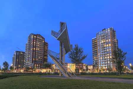 View over water to typically residential apartments towers "de Elementen" at night near the heemkanaal at the suburban Oosterheem, Zoetermeer, the Netherlands during duskの写真素材