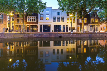 Street view on canals and monumental houses in historical city Gouda, the Netherlands during duskのeditorial素材