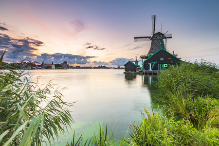 Traditional Dutch windmills near water at sunset, Zaanse Schans, Amsterdam