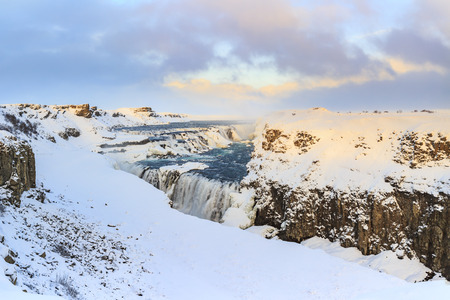 Gullfoss waterfalls located along the golden circle route, Iceland during Winter season. Ice, snow, water and sunset.の写真素材