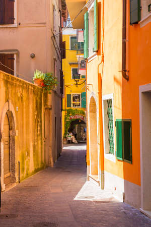 Beautiful colored hous facades in the narrow streets in Garda village, Italyの写真素材