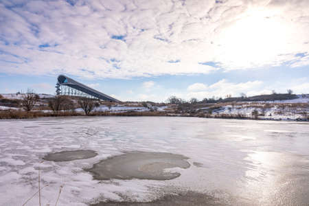 Snowy landscape with hills and meadows under a blue sky in Winter season. Buytenpark Zoetermeer, the...