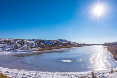 Snowy and ice winter landscape at the Amsterdamse Waterleidingduinen, clear blue sky.の写真素材