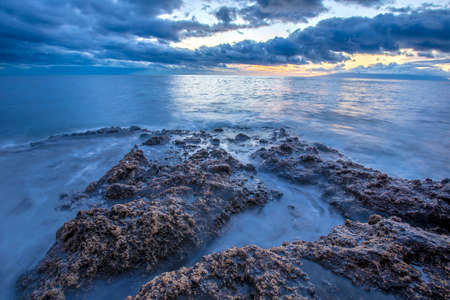 Beautiful sunset on Tenerife canary island coast with rocks and bluewaterの写真素材