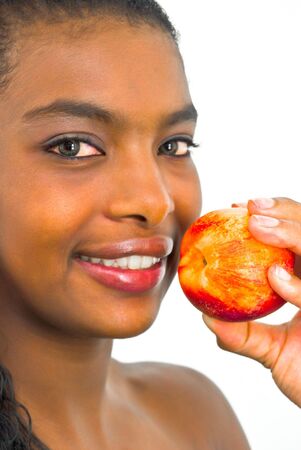 sweet smiling african girl with a peach in her handの写真素材