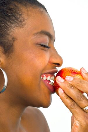 laughing african girl with a peachの写真素材