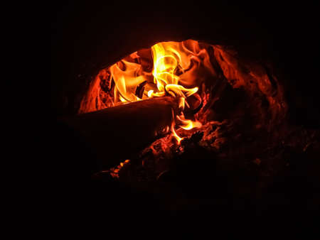 Burning fire in a wood-coal oven on a winter night close-up shot.