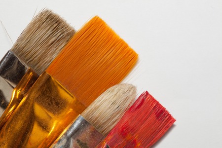 New and spoiled red and orange paint paint brushes
