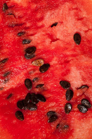 Red core of ripe watermelon with dark brown seedsの写真素材