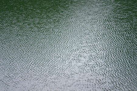 The surface texture of water, covered with small ripplesの写真素材
