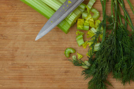 green celery and dill on a wooden cutting boardの写真素材