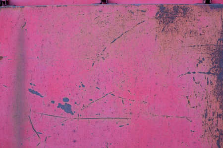 Rusty metal sheet covered with red paint