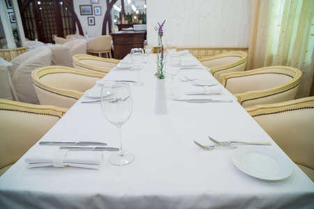 Forks, knives and glasses on the table in a modern restaurantの写真素材