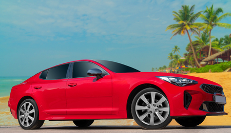 Red car on a background of palm trees. Stylish, modern, bright image of the car for design solutions.の写真素材