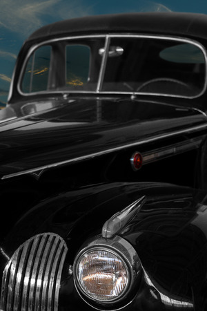 Vintage, black, shiny car against the background of the night sky.の写真素材