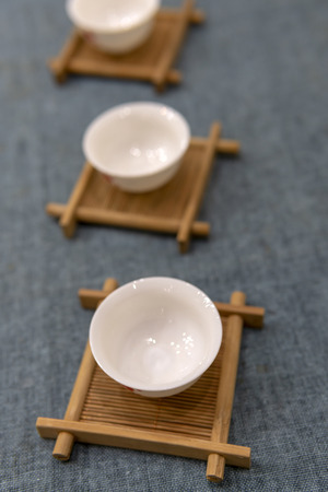 White Chinese tea cup on a wooden stand.の写真素材
