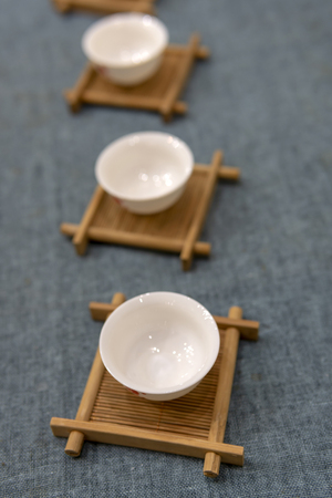 White Chinese tea cup on a wooden stand.の写真素材