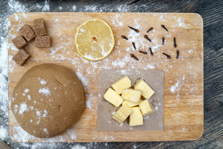 on the kitchen table. Ingredients - butter, lemon, flour, sugar, cloves.の写真素材