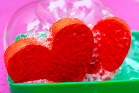 Two red hearts in soapsuds.の写真素材