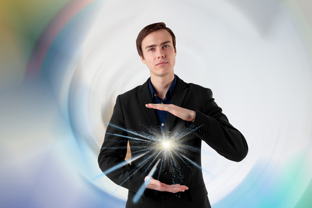 Young scientist on a futuristic background. Energy in the hands. Insight.の写真素材