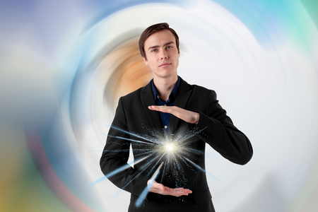 Young scientist on a futuristic background. Energy in the hands. Insight.の写真素材