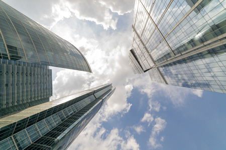 Modern glass skyscrapers. White clouds reflected in the mirrored walls.の写真素材