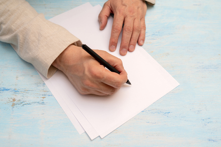 A pen in a man's hand. White sheet of paper. Signing a document.の写真素材