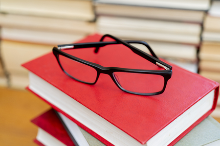 Glasses on the background of books. Symbol of knowledge, science, study, wisdom.の写真素材