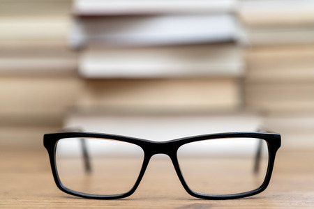 Glasses on the background of books. Symbol of knowledge, science, study, wisdom.の写真素材