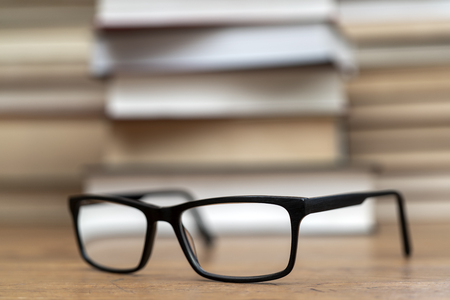 Glasses on the background of books. Symbol of knowledge, science, study, wisdom.の写真素材