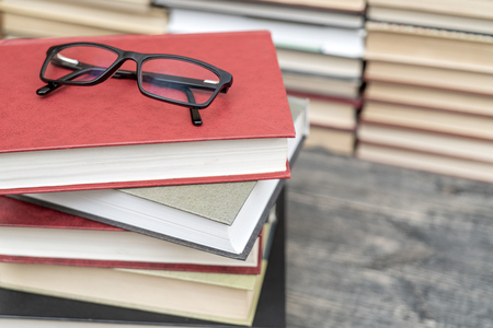 Glasses on the background of books. Symbol of knowledge, science, study, wisdom.の写真素材