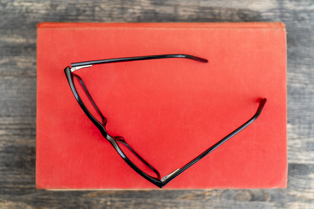 Glasses on the background of books. Symbol of knowledge, science, study, wisdom.の写真素材