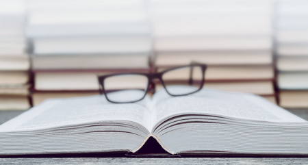 Glasses on the background of books. Symbol of knowledge, science, study, wisdom.の写真素材