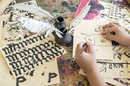 Exercises on spelling and calligraphy on yellow paper with a bird feather.の写真素材