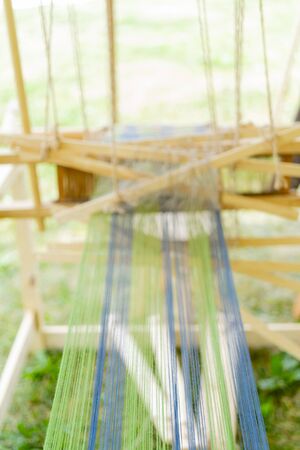 Blue and green threads in an old wooden machine.の写真素材