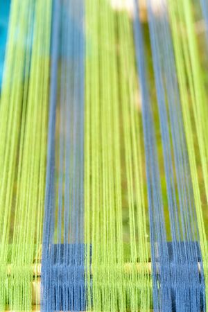 Blue and green threads in an old wooden machine.の写真素材
