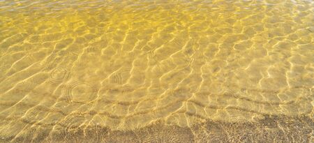 Transparent water of the lake on sandy shallow water.の写真素材