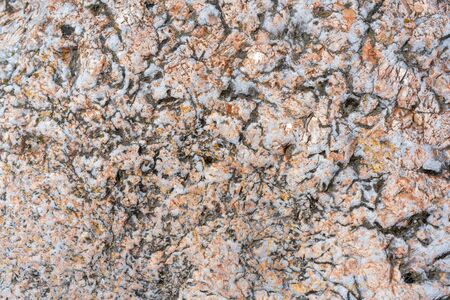 Cracked stone surface. The texture of pink granite.の写真素材
