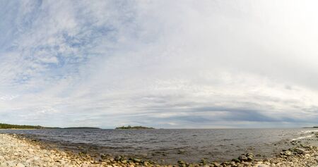 The sky above the pebble beach on the lake.の写真素材