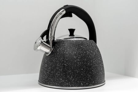 Modern kettle on gray background in kitchen.の写真素材